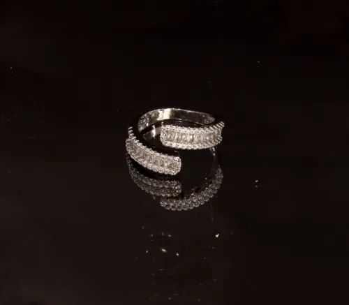 خاتم نسائي فاخر بتصميم حلقة مفتوحة ملتفة (Bypass Ring) مرصع بحصى الباجيت وزيركون باللون الفضي البراق