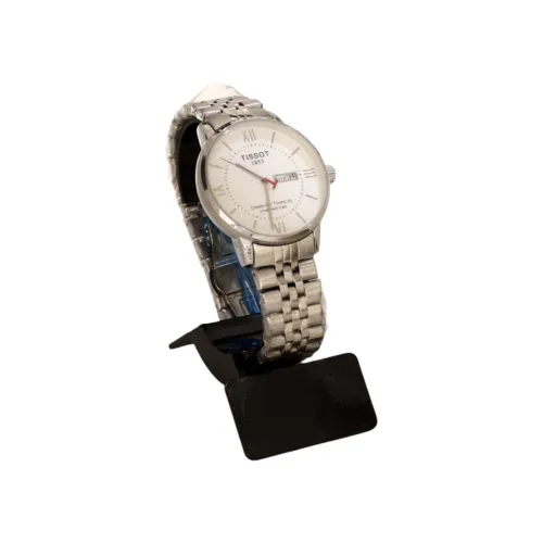 ساعة يد رجالية فاخرة من "Tissot" بستايل كلاسيكي وميناء أبيض بأرقام رومانية مع نافذة لليوم والتاريخ وسوار معدني فضي